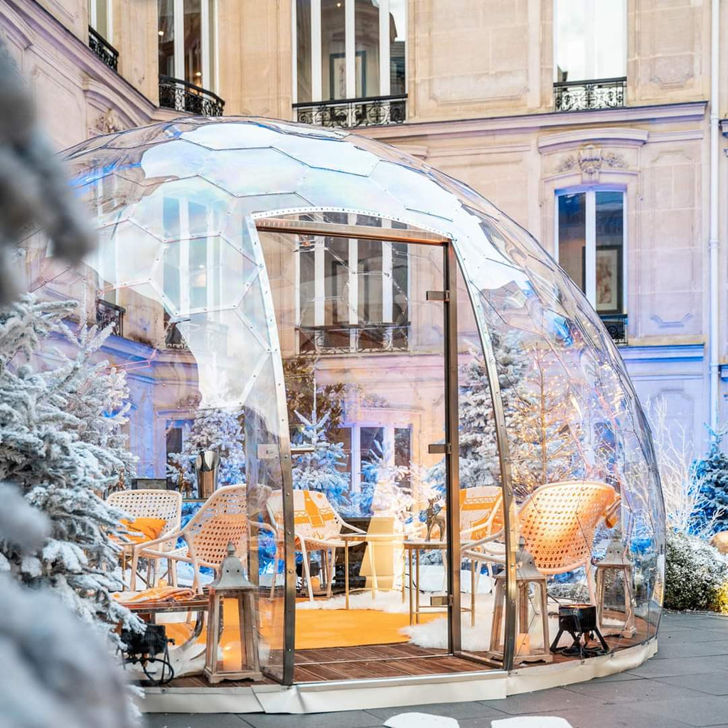 Outdoor dining dome with glass door, white Christmas trees and restaurant