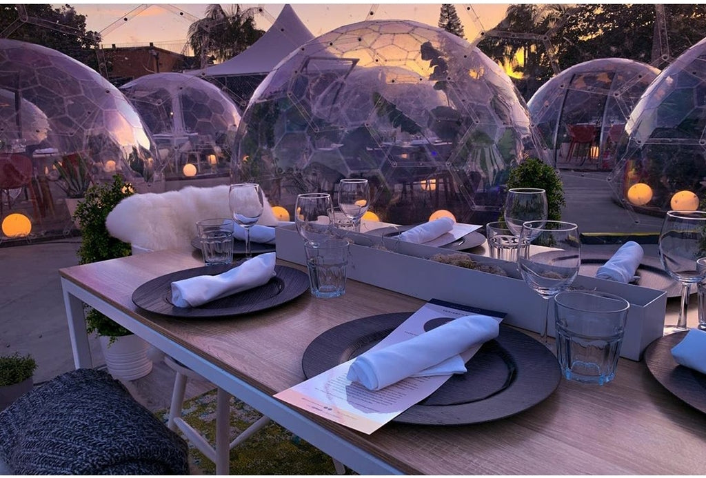 Perspex dining igloos with circular LED lights at dusk