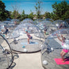 Multiple outdoor Perspex domes being used for hot Yoga in the bright sunshine
