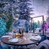 outdoor dining dome surrounded by snow covered trees 