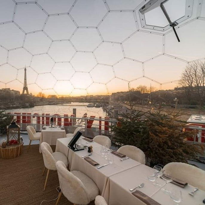 Outdoor dining dome with the Eiffel Tower in the background and the spin river flowing below